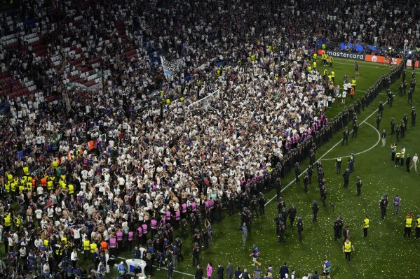 Fans of PSG invade the pitch after the Champions League final soccer match between Paris Saint-Germain and Inter Milan at the Allianz Arena in Munich, Germany, Saturday, May 31, 2025. (AP Photo/Michael Probst)