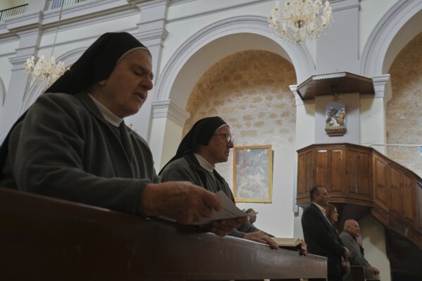 Maronite Catholic nuns recite hymns during a service in outside St. George Church in the Maronite village of Kormakitis in the breakaway north of the ethnically divided Cyprus on Wednesday, April 23, 2025. (AP Photo/Petros Karadjias)