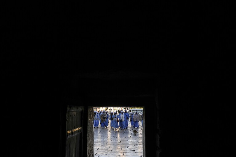 Nigerian worshippers walk along the Church of the Nativity, traditionally believed to be the birthplace of Jesus, on Christmas Eve, in the West Bank city of Bethlehem, Tuesday, Dec. 24, 2024. (AP Photo/Matias Delacroix)