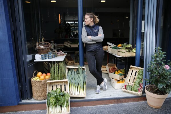 FILE - In this Friday, March 27, 2020 file photo, chef Amandine Chaignot waits for customers as she turns her restaurant into a shop to sell vegetables during the lockdown of coronavirus, in Paris. European Union leaders are preparing for a new virtual summit, which will take place Thursday, April 23, 2020, to take stock of the damage the coronavirus has inflicted on the lives and livelihoods of the bloc's citizens and to thrash out a more robust plan to revive their ravaged economies. (AP Photo/Francois Mori, File)