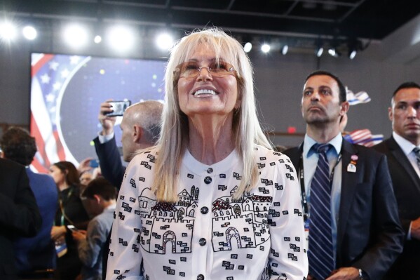 FILE - Miriam Adelson, wife of Las Vegas Sands Corporation Chief Executive and Republican mega donor Sheldon Adelson, listens as President Donald Trump speaks at the Israeli American Council National Summit in Hollywood, Fla., Saturday, Dec. 7, 2019. Miriam Adelson, the controlling shareholder of casino company Las Vegas Sands Corp., plans to sell $2 billion in company stock and buy an unspecified professional sports franchise, the company announced Tuesday, Nov. 28, 2023. Dallas Mavericks owner Mark Cuban is working on a deal to sell a majority stake in the NBA franchise to the Adelson family, a person with knowledge of the talks said late Tuesday. (AP Photo/Patrick Semansky, File)