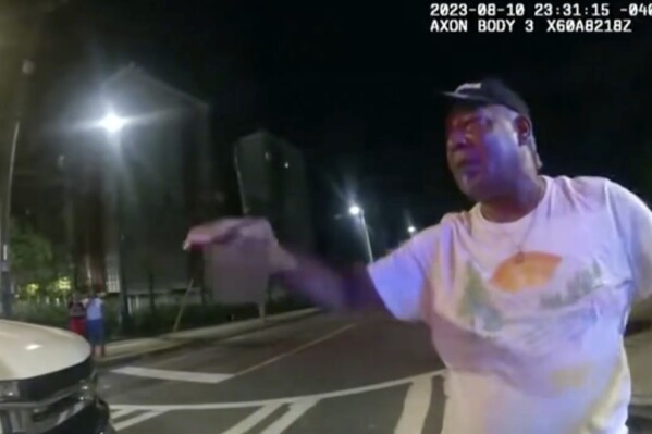 This image from bodycam video provided by the Atlanta Police Department shows Johnny Hollman Sr. speaking with Officer Kiran Kimbrough on Aug. 10, 2023 in Atlanta. The police officer responding to a minor car crash deployed a Taser on the church deacon who disregarded multiple commands to sign a traffic ticket, shocking the man after he repeatedly said he could not breathe, police body camera video released Wednesday, Nov. 22, 2023 shows. Hollman Sr. became unresponsive during his arrest and later died. (Atlanta Police Department via AP)