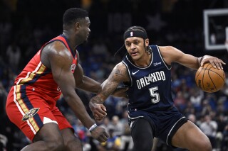 Orlando Magic forward Paolo Banchero (5) is defended by New Orleans Pelicans forward Zion Williamson during the first half of an NBA basketball game, Thursday, March 21, 2024, in Orlando, Fla. (AP Photo/Phelan M. Ebenhack)