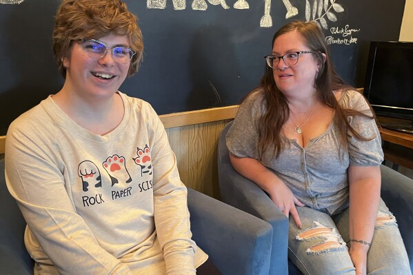 Nola Rhea, 17, left, and her mother, Heather Rhea, 47, sit together in a coffee shop on Sept. 26, 2023, in Lincoln, Neb., as they discuss Nola's plans to leave the state of Nebraska next year to attend college following the state's enactment of a law restricting gender-confirming medical treatments for minors. Nola is a transgender teen who says she no longer feels welcomed in Nebraska. (AP Photo/Margery Beck)