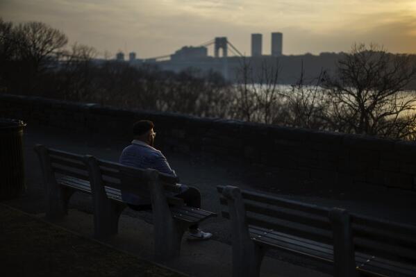 Adam Almonte sits on a bench overlooking the Hudson River where he used to sit and eat tuna sandwiches with his older brother, Fernando Morales, in Fort Tryon Park in New York, Wednesday, March 16, 2022. On the deadliest day of a horrific week in April 2020, COVID-19 took the lives of 816 people in New York City alone. Lost in the blizzard of pandemic data that's been swirling ever since is the fact that 43-year-old Morales was one of them. Soon, likely in the next few weeks, the U.S. toll from the coronavirus will surpass 1 million. (AP Photo/David Goldman)