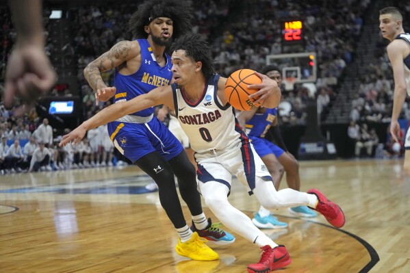 Gonzaga guard Ryan Nembhard (0) drives around McNeese State guard Mike Saunders Jr., left, during the first half of a first-round college basketball game in the NCAA Tournament in Salt Lake City, Thursday, March 21, 2024. (AP Photo/Rick Bowmer)