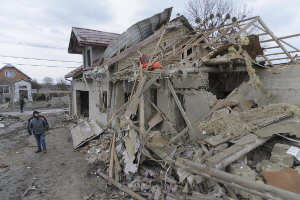 A villager passes by debris of private houses ruined in Russia's night rocket attack in a village, in Zolochevsky district in the Lviv region, Ukraine, Thursday, March 9, 2023. (AP Photo/Mykola Tys)