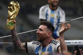 Argentina's Lionel Messi celebrates with the trophy after winning the World Cup final soccer match between Argentina and France at the Lusail Stadium in Lusail, Qatar, Sunday, Dec.18, 2022. (AP Photo/Manu Fernandez)