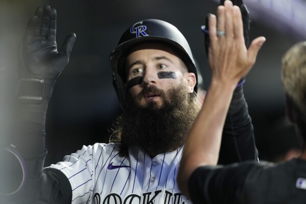 Colorado Rockies' Charlie Blackmon is congratulated as he returns to the dugout after hitting a solo home run against Los Angeles Dodgers starting pitcher Ryan Yarbrough in the first inning of a baseball game Thursday, Sept. 28, 2023, in Denver. (AP Photo/David Zalubowski)