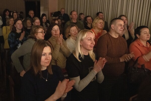 Spectators applaud actresses playing male roles on the stage of the Chernihiv Regional Youth Theater, which reinvented itself with an all-female cast, with most male actors at war, in Chernihiv, Ukraine, Sunday, Feb. 16, 2025. (AP Photo/Efrem Lukatsky)