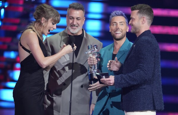 Joey Fatone, from center, Lance Bass, and Justin Timberlake of NSYNC, present the award for best pop to Taylor Swift, for "Anti-Hero" during the MTV Video Music Awards on Tuesday, Sept. 12, 2023, at the Prudential Center in Newark, N.J. (Photo by Charles Sykes/Invision/AP)
