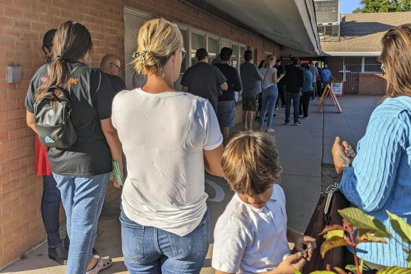 FILE - Voters wait to cast their ballots at Memorial Presbyterian Church, a busy polling place in central Phoenix, Nov. 8, 2022. Republicans are re-evaluating their antipathy to mail voting. After former President Donald Trump condemned that method of casting ballots in 2020, conservatives shied away from it. That's given Democrats a multiweek jump on voting during elections. (AP Photo/Nathan Ellgren, File)