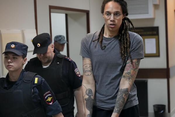 FILE - WNBA star and two-time Olympic gold medalist Brittney Griner is escorted from a courtroom after a hearing in Khimki just outside Moscow, Russia, Aug. 4, 2022. The Biden administration should create a new position at the White House National Security Council to focus on cases of Americans wrongfully detained in foreign countries. That's according to a report from an advocacy group, which recommends funding an interagency office to help free hostages. The U.S. has been trying to bring home Griner and another American jailed in Russia, Paul Whelan, but those efforts have so far not been successful. (AP Photo/Alexander Zemlianichenko, File)