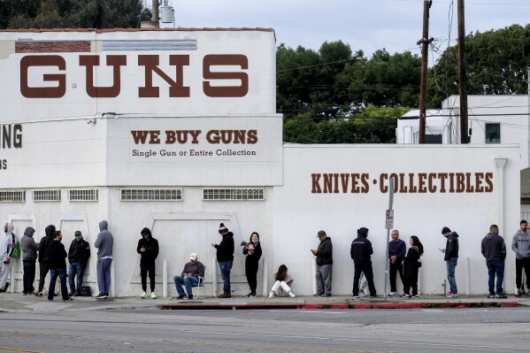 FILE – People wait to enter a gun store in Culver City, Calif., on Sunday, March 15, 2020. A federal judge has struck down a California law Wednesday, Dec. 20, 2023, that would ban people from carrying guns in most public places. It's one of several legal challenges pending against California's gun laws. (AP Photo/Ringo H.W. Chiu, File)