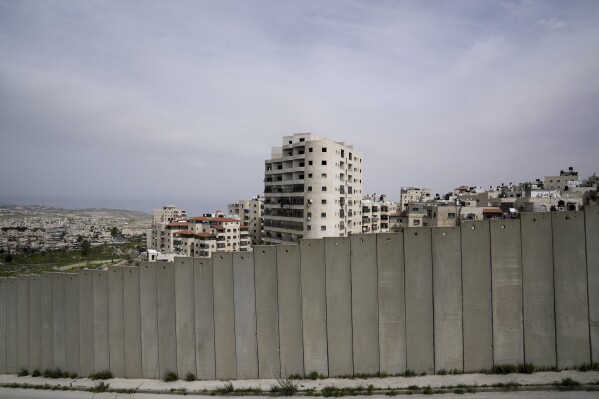 A view of Shuafat refugee camp is seen behind a section of Israel's separation barrier in Jerusalem on Sunday, March 17, 2024. Palestinian boy Rami Halhouli, 12, was fatally shot by an Israeli police officer while launching a firework in the refugee camp on March 12. (AP Photo/Mahmoud Illean)