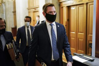 FILE - In this Feb. 10, 2021, file photo, Rep. Eric Swalwell, D-Calif., walks at the Capitol, in Washington. The House has rejected an attempt to boot a Democrat from the House intelligence committee. Democrats scuttled a Republican effort to remove Swalwell from the intelligence panel. The resolution against Swalwell cited reporting that he had contact more than six years ago with a suspected Chinese spy who targeted politicians in California. (Joshua Roberts/Pool via AP, File)
