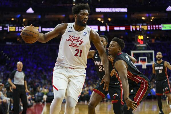 Philadelphia 76ers' Joel Embiid, left, looks to make his move against Miami Heat's Kyle Lowry, right, and Haywood Highsmith, center, during the second half an NBA basketball game, Thursday, April 6, 2023, in Philadelphia. (AP Photo/Chris Szagola)