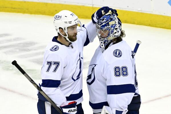 Tampa Bay Lightning defenseman Victor Hedman (77) and Tampa Bay Lightning goaltender Andrei Vasilevskiy (88) celebrate after the Lightning defeated the New Jersey Devils 6-3 in an NHL hockey game Tuesday, Feb. 15, 2022, in Newark, N.J. (AP Photo/Bill Kostroun)
