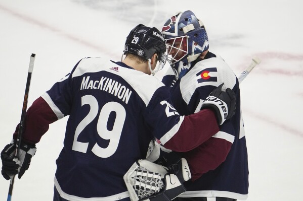 Colorado Avalanche center Nathan MacKinnon (29) and goaltender Alexandar Georgiev (40) congratulate each other after an NHL hockey game against the Minnesota Wild Tuesday, April 9, 2024, in Denver. (AP Photo/Bart Young)