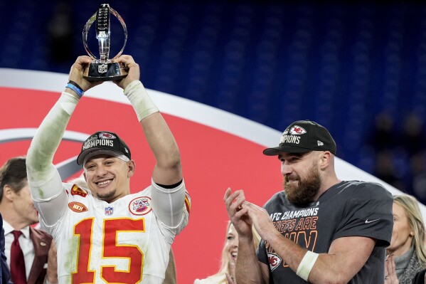 Kansas City Chiefs quarterback Patrick Mahomes (15) holds the Lamar Hunt trophey as Kansas City Chiefs tight end Travis Kelce looks on after an AFC Championship NFL football game against the Baltimore Ravens, Sunday, Jan. 28, 2024, in Baltimore. The Kansas City Chiefs won 17-10. (AP Photo/Alex Brandon)