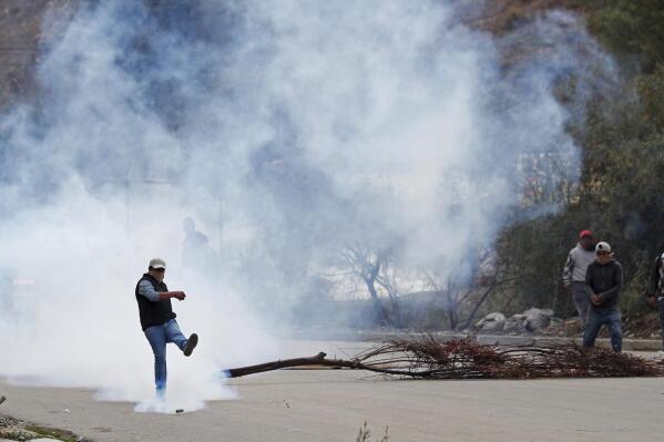 FILE - In this Nov. 11, 2019 file photo, a man kicks a tear gas canister during clashes between police and supporters of former President Evo Morales who set up barricades in La Paz, Bolivia. Former senior Bolivian official Sergio Rodrigo Mendez was arrested for seeking kickbacks from a group of Florida-based businessmen allegedly selling tear gas at inflated prices to the conservative government of former interim President Jeanine Anez, who took power in November 2019 after Morales stepped down amid violent protests disputing his re-election to a fourth straight term. (AP Photo/Juan Karita, File)