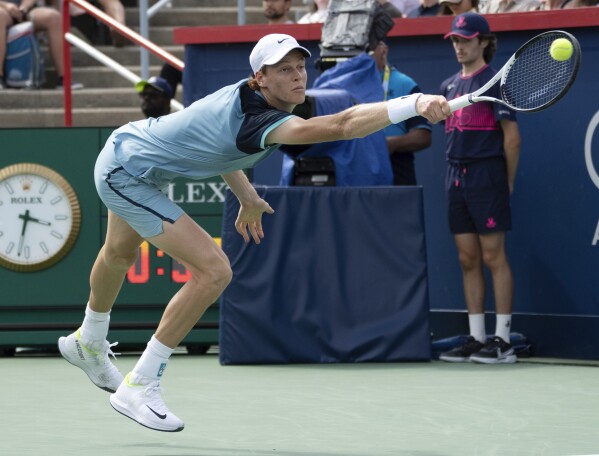 CORRECTS TO BORNA CORIC NOT BORJA CORIC - Italy's Jannik Sinner lunges for a shot from Croatia's Borna Coric during their second-round match at the National Bank Open tennis tournament Thursday, Aug. 8, 2024, in Montreal. (Ryan Remiorz/The Canadian Press via AP)