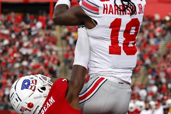 Ohio State wide receiver Marvin Harrison Jr. (18) makes a catch for a touchdown over Rutgers defensive back Robert Longerbeam (7) during the second half of a NCAA college football game, Saturday, Nov. 4, 2023, in Piscataway, N.J. (AP Photo/Noah K. Murray)