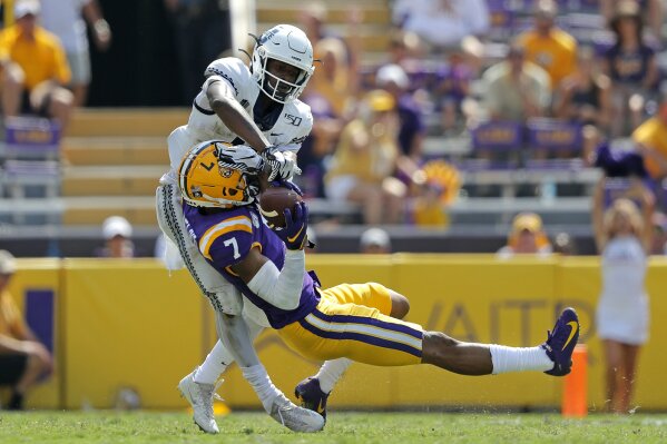 FILE - In this Oct. 5, 2019, file photo, LSU safety Grant Delpit (7) pulls in an interception against Utah State wide receiver Savon Scarver in the second half of an NCAA college football game in Baton Rouge, La. Delpit was selected to the AP Midseason All-America NCAA college football team, Tuesday, Oct. 15, 2019.  (AP Photo/Gerald Herbert, File)