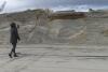 A beachgoer takes a photo of a severely eroded dune in North Wildwood, N.J. on Jan. 5, 2023 where a ramp down to the beach used to exist but now dead-ends in mid-air. North Wildwood, which is defying a state order not to do emergency repairs to its eroded beach, is suing New Jersey for $21 million, asserting it has spent that amount trucking sand in to widen its beaches in the absence of a government beach replenishment project. (AP Photo/Wayne Parry)