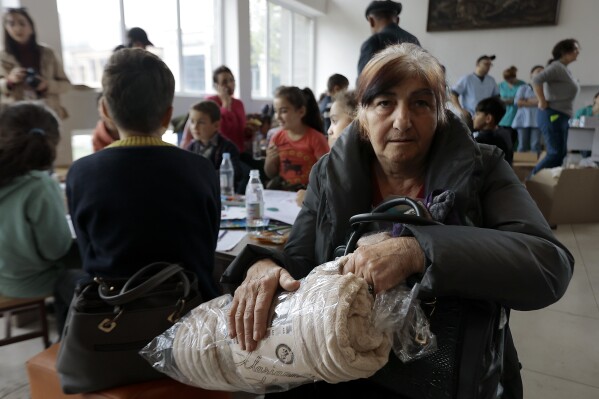 Ethnic Armenians from Nagorno-Karabakh gather as they wait to receive humanitarian aid at a temporary camp in Armenia's Goris in Syunik region, Armenia, on Tuesday, Sept. 26, 2023. Thousands of Armenians have streamed out of Nagorno-Karabakh after the Azerbaijani military reclaimed full control of the breakaway region last week. (AP Photo/Vasily Krestyaninov)