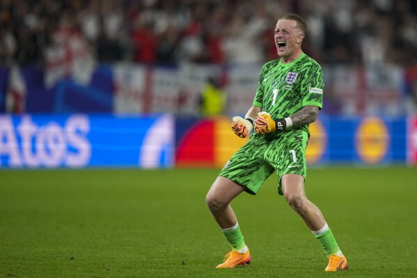 England's goalkeeper Jordan Pickford celebrates at the end of a Group C match between Serbia and England at the Euro 2024 soccer tournament in Gelsenkirchen, Germany, Sunday, June 16, 2024. (AP Photo/Martin Meissner)