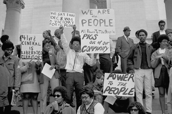 FILE - In this Dec. 11, 1969, file photo, demonstrators protest on the steps of the Los Angeles City Hall, against raids by police at Black Panther headquarters. It once would have been unthinkable for a city to erect a monument to Huey P. Newton, the Black Panther Party co-founder who was feared and hated by many Americans. Members of the party were dismissed as racist, gun-toting militants. (AP Photo/Wally Fong, File)