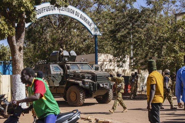 FILE - Burkina Faso mutinous soldiers guard the entrance of the national television station in Ouagadougou, Monday Jan. 24, 2022. A slew of extrajudicial killings, forced disappearances, and instances of torture by Burkina Faso's military has terrorized communities in the country's northeast this year, according to a Human Rights Watch report released Thursday, June29, 2023. (AP Photo/Sophie Garcia, File)