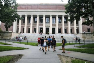 FILE - In this Aug. 13, 2019 file photo, students walk near the Widener Library in Harvard Yard at Harvard University in Cambridge, Mass. Ismail Ajjawi, 17, a Palestinian student who was denied entry to the United States just days before he was scheduled to start classes at Harvard University, has been admitted to the country. The university confirmed that Ajjawi was on campus as classes began Tuesday, Sept. 3, 2019. (AP Photo/Charles Krupa, File)