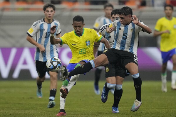 Brazil's Estevao, left, battles for the ball against Argentina's Mariano Gerez during their FIFA U-17 World Cup quarterfinal soccer match at Jakarta international Stadium in Jakarta, Indonesia, Friday, Nov. 24, 2023. (AP Photo/Achmad Ibrahim)