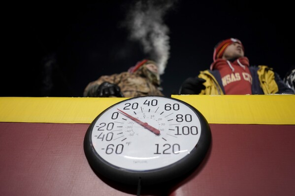 FILE - A gauge displays the temperature on the field at Arrowhead Stadium during the first half of the NFL playoff game between the Kansas City Chiefs and Miami Dolphins, Jan. 13, 2024, in Kansas City, Missouri.  The United States is shivering from the extreme cold, while most of the world is experiencing unusually warm weather.  This fits with what climate change is doing to the Earth, scientists say Tuesday, January 16.  (AP Photo/Charlie Riddell, File)