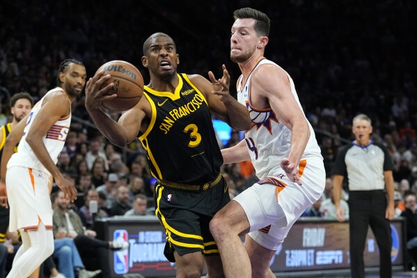 Golden State Warriors guard Chris Paul (3) is fouled by Phoenix Suns forward Drew Eubanks (14) during the first half of an NBA basketball game, Wednesday, Nov. 22, 2023, in Phoenix. (AP Photo/Matt York)