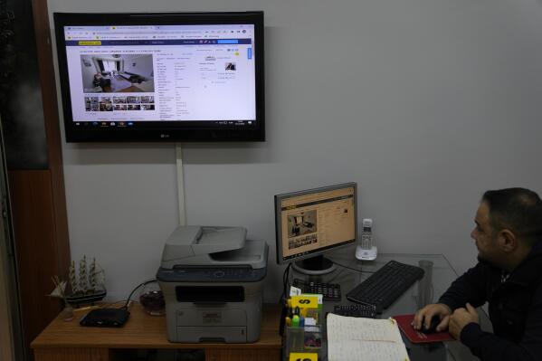 A Real Estate agent checks online posts of apartments for rent, in his office in Istanbul, Tuesday Dec. 8, 2022. Economic turmoil driven by inflation of 85% has plunged Turkey into one of its worst property crises. Skyrocketing prices have made finding affordable housing to rent or buy an uphill battle for many, especially for millions earning minimum wage who also struggle to cover food and energy costs. Increasing construction costs and inflation have pushed up housing prices globally. (AP Photo/Khalil Hamra)