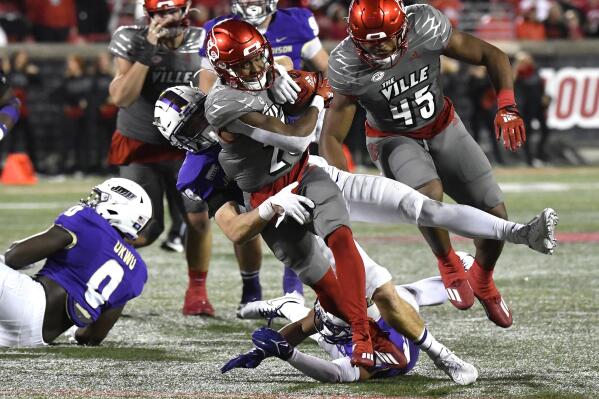 Louisville running back Jawhar Jordan (25) is brought down by James Madison safety Francis Meehan (49) during the second half of an NCAA college football game in Louisville, Ky., Saturday, Nov. 5, 2022. Louisville won 34-10. (AP Photo/Timothy D. Easley)