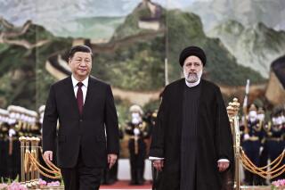 FILE - In this photo released by Xinhua News Agency, visiting Iranian President Ebrahim Raisi, right, walks with Chinese President Xi Jinping after reviewing an honor guard during a welcome ceremony at the Great Hall of the People in Beijing, Tuesday, Feb. 14, 2023. China and Iran have urged mutual neighbor Afghanistan to end restrictions on women’s work and education. The call came in a joint statement Thursday, Feb. 16, 2023, issued at the close of Raisi's visit to Beijing in which the sides affirmed close economic and political ties and their rejection of Western standards of human rights and democracy. (Yan Yan/Xinhua via AP, File)