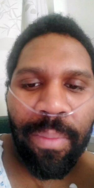 This April 2020 photo provided by Warnell Vega, 33, shows him in a hospital in New York. Vega collapsed at home April 19 from a large clot blocking a lung artery. Doctors at Mount Sinai Morningside think it was coronavirus-related. Vega, 33, a lunch maker for New York City school children, spent a week in intensive care on oxygen and blood thinners, which he's been told to continue taking for three months. “I just have to watch out for any bleeding, and have to be careful not to cut myself,” he said. (Warnell Vega via AP)