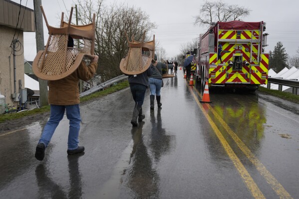 Attendees carry off there purchases from the 56th annual mud sale to benefit the local fire department in Gordonville, Pa., Saturday, March 9, 2024. Mud sales are a relatively new tradition in the heart of Pennsylvania's Amish country, going back about 60 years and held in early spring as the ground begins to thaw but it's too early for much farm work. (AP Photo/Matt Rourke)