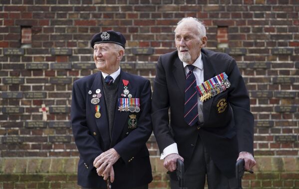 D-Day veterans Stan Ford, left, and John Roberts before receiving their memorial plaques in front of the Normandy Memorial Wall in Portsmouth, England, Tuesday Feb. 27, 2024. With medals pinned to their chests, the two D-Day veterans proudly represented their comrades as 13 new names were added to the memorial wall in southern England that honors those who took part in the Normandy landings. (Gareth Fuller/PA via AP)