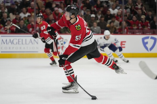 Chicago Blackhawks defenseman Kevin Korchinski clears the puck of his team's zone during the first period of an NHL hockey game against the Toronto Maple Leafs, Friday, Nov. 24, 2023, in Chicago. (AP Photo/Erin Hooley)
