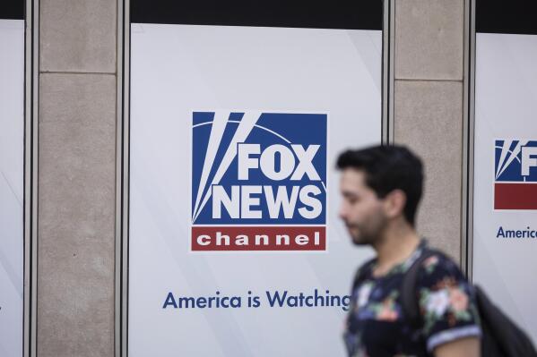 FILE - A person walks past the Fox News Headquarters in New York, April 12, 2023. Fox News’ nearly $800 million settlement of a voting machine company's defamation lawsuit marks the first milestone in a larger legal strategy designed to combat the false claims and conspiracy theories about elections that have been rippling through the U.S. for nearly three years. (AP Photo/Yuki Iwamura, File)