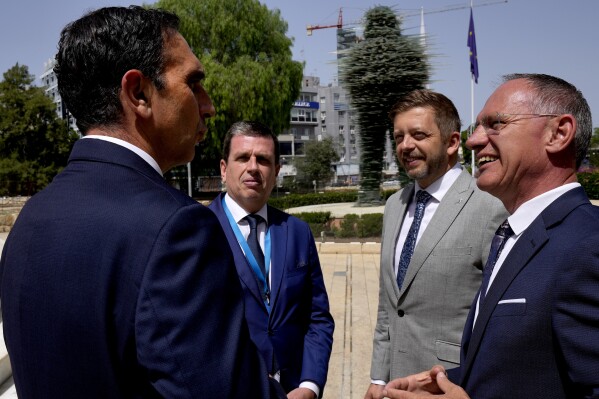 Cyprus' interior minister Konstantinos Ioannou, left, talks with his counterparts Austria's Gerhard Karner, right, Czech's Vít Rakusan, second right, and Greece's Minister Of Immigration and Asylum Dimitris Kairides, second left, during the Ministerial Summit Migration and Syria Dynamics in capital Nicosia, Cyprus, Friday, May 17, 2024. The governments of eight European Union member states say the situation inside Syria should be re-evaluated to allow for voluntary returns of Syrian refugees back to their homeland. (AP Photo/Petros Karadjias)