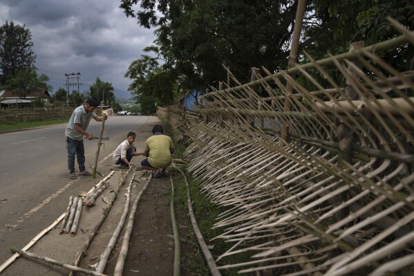 Tribal Kuki community members set up fortifications made of bamboo around their houses, chiseling its edges in the shape of spears in Kuki-controlled Churachandpur district, in the northeastern Indian state of Manipur, Tuesday, June 20, 2023. Manipur is caught in a deadly conflict between two ethnic communities that have armed themselves and launched brutal attacks against one another. At least 120 people have been killed since May. (AP Photo/Altaf Qadri)