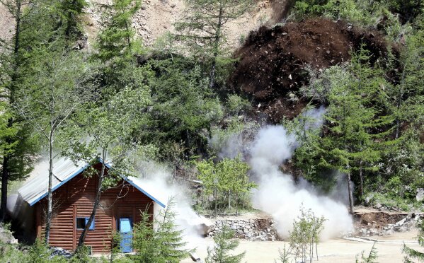 
              This Thursday, May 24, 2018 photo, shows smoke and debris in the air as the entrance to the tunnel at North Korea's nuclear test site is blown up in Punggye-ri, North Korea. (Korea Pool/Yonhap via AP)
            
