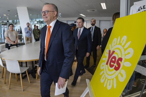 Australian Prime Minister Anthony Albanese, foreground, walks past a "Yes" sign, referring to upcoming referendum, as he arrives for a press conference at South Australian Health and Medical Research Institute in Adelaide, Thursday, Sept. 21, 2023. A record number of Australians enrolled to vote in a referendum that would create an Indigenous advocacy body, as the first ballots for constitutional change are set to be cast in remote Outback locations next week, officials said on Thursday. (Roy Vandervegt/AAP Image via AP)