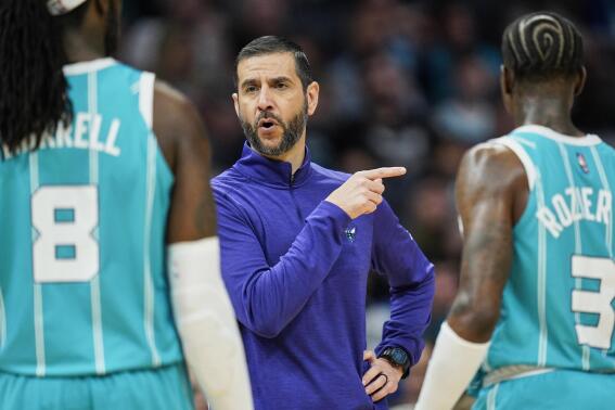 Charlotte Hornets head coach James Borrego, center, gives instruction to Charlotte Hornets center Montrezl Harrell (8) and guard Terry Rozier (3) during the first half of an NBA basketball game against the Orlando Magic on Thursday, April 7, 2022, in Charlotte, N.C. (AP Photo/Rusty Jones)